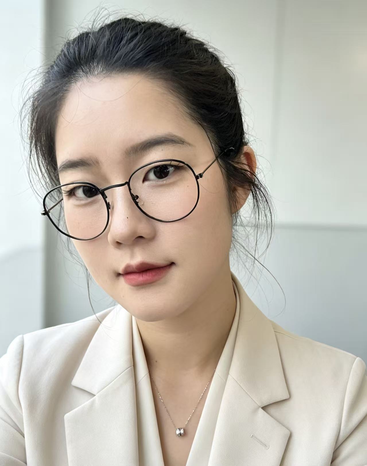 方婷的个人照片，戴着圆框眼镜，身穿米白色西装